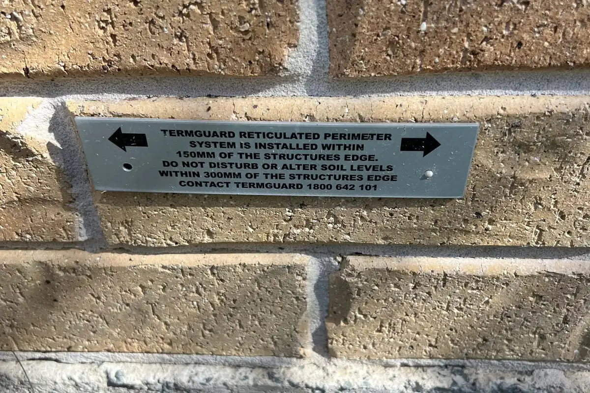 Termguard reticulated perimeter system marker plate fixed to a brick wall